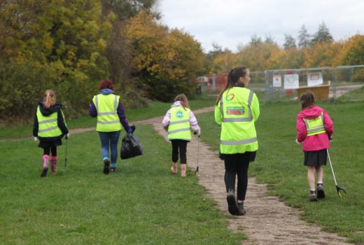 children cleaning the path in a park